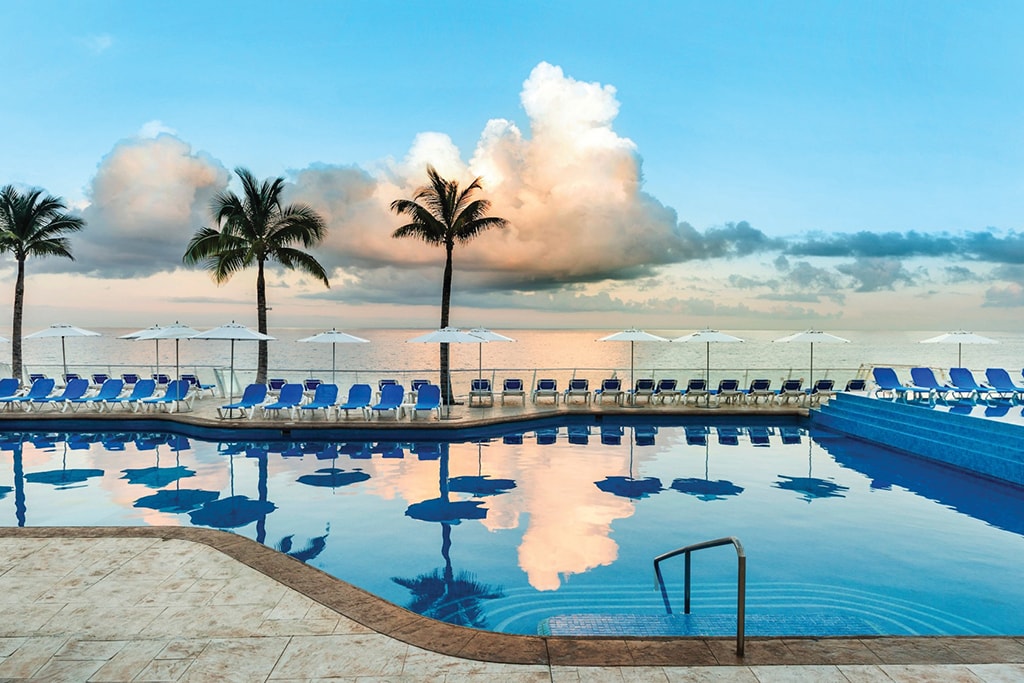 The pool deck is elevated above the shore to provide sweeping water views.