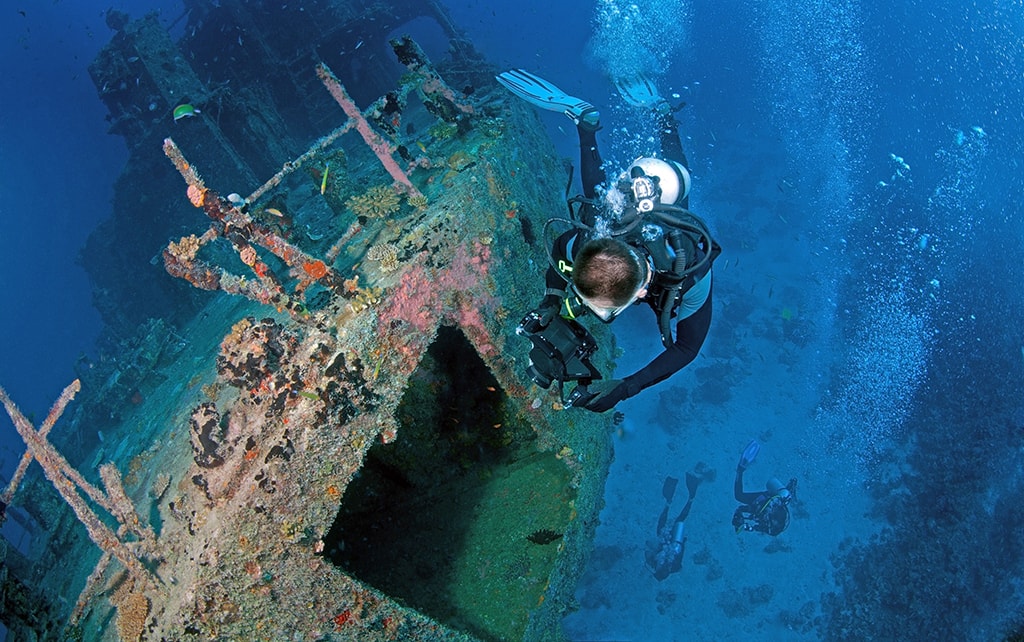 Divers explore the Marcha Fushi wreck, which is located in the waters of South Ari Atoll.