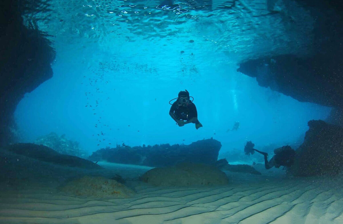 A diver enters the submerged cavern known as the Blue Room.