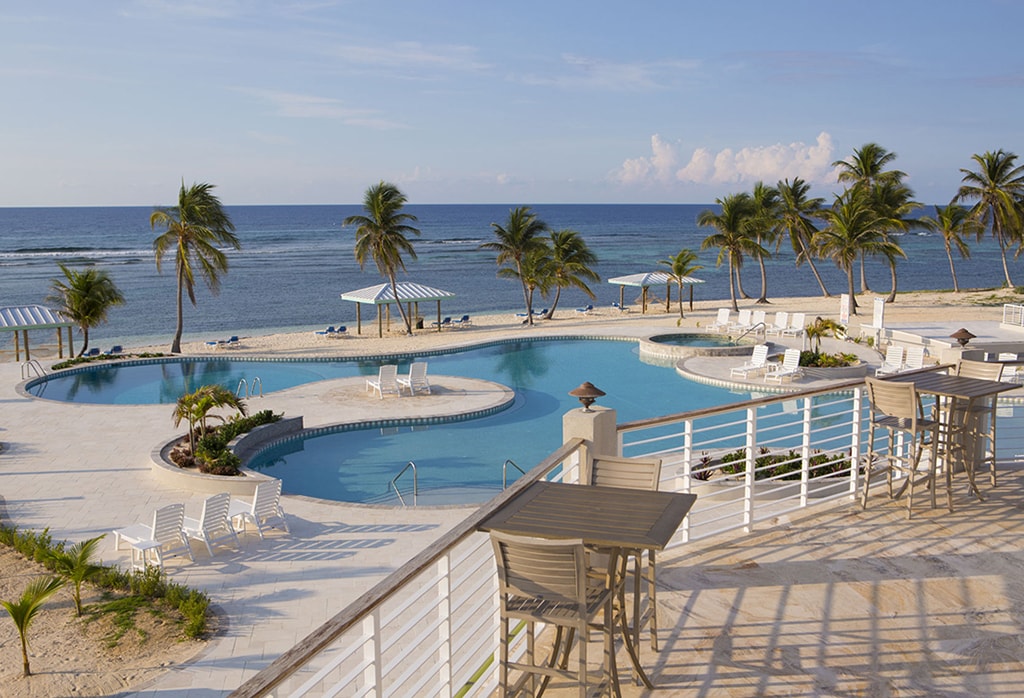 The second-story deck at Cayman Brac Beach Resort takes in views of pool and ocean.