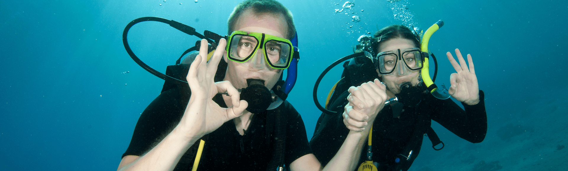 Couple giving scuba diving OK sign