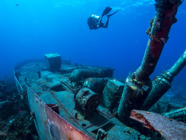 A scuba diver explores a ship wreck in the Bahamas