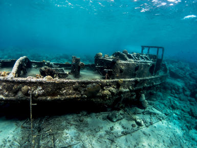 Tugboat wreck lying in the sunlit shallows in Curacao